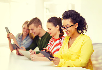 Image showing smiling students looking at tablet pc at school