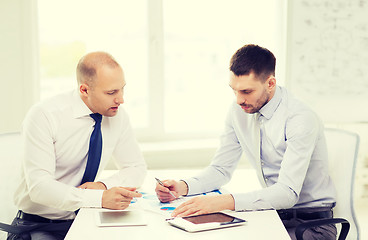 Image showing two serious businessmen with tablet pc in office