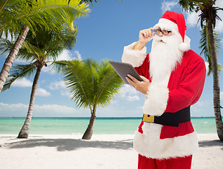 Image showing man in costume of santa claus with tablet pc