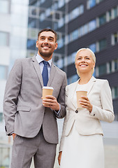 Image showing smiling businessmen with paper cups outdoors