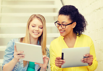 Image showing smiling female students with tablet pc computer