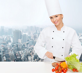 Image showing smiling female chef chopping vegetables