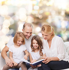 Image showing happy family with book at home