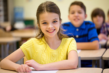 Image showing group of school kids with notebooks in classroom