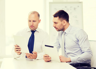 Image showing two serious businessmen with tablet pc in office