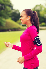 Image showing smiling young woman running outdoors