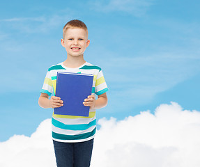 Image showing smiling little student boy with blue book