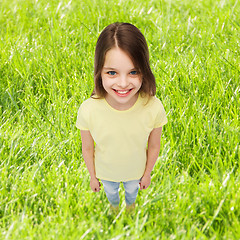 Image showing smiling little girl over green grass background