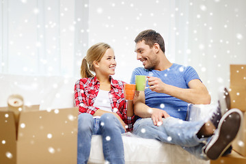 Image showing smiling couple drinking tea or coffee at new home