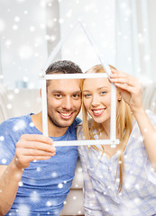 Image showing smiling couple holding house model at home