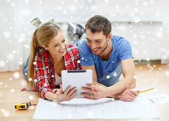 Image showing smiling couple with  blueprint at home