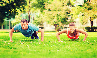 Image showing couple doing push-ups outdoors