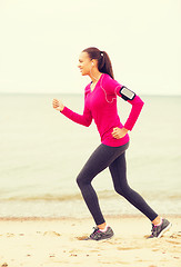 Image showing smiling young woman running outdoors