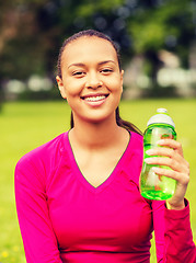 Image showing smiling teenage girl showing bottle