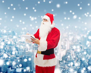 Image showing man in costume of santa claus with notepad