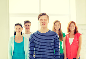 Image showing smiling students with teenage boy in front