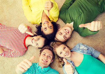 Image showing group of smiling people lying down on floor