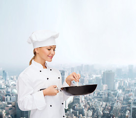 Image showing smiling female chef with pan and spoon