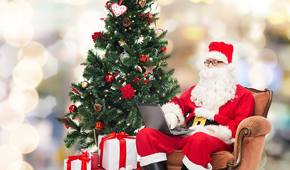 Image showing man in costume of santa claus with laptop