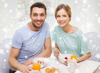 Image showing smiling couple having breakfast at home