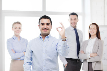 Image showing smiling businessman showing ok-sign in office