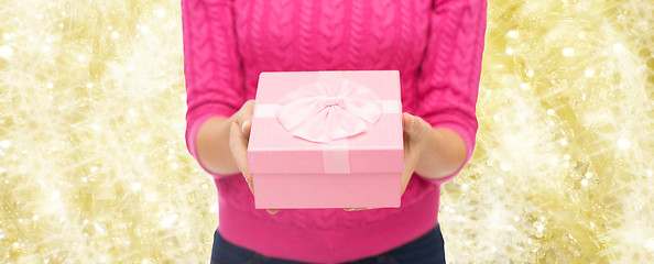 Image showing close up of woman in pink sweater holding gift box