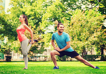 Image showing smiling couple stretching outdoors