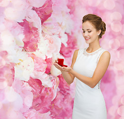 Image showing smiling woman holding red gift box with ring