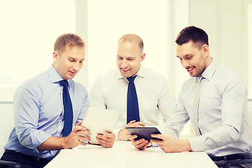 Image showing three smiling businessmen with tablet pc in office