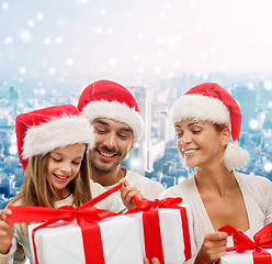 Image showing happy family in santa helper hats with gift boxes