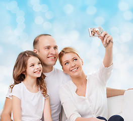 Image showing happy family with camera at home