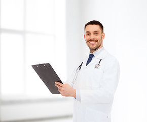 Image showing smiling male doctor with clipboard and stethoscope