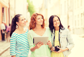 Image showing smiling teenage girls with tablet pc and camera