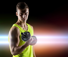 Image showing young man with dumbbell flexing biceps