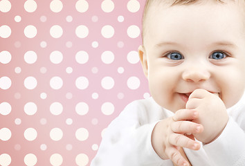 Image showing smiling baby girl face over pink polka dots