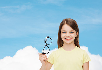 Image showing smiling cute little girl holding black eyeglasses