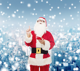 Image showing man in costume of santa claus with notepad