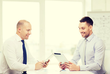 Image showing two smiling businessmen with tablet pc in office