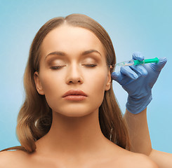 Image showing beautiful woman face and hand with syringe