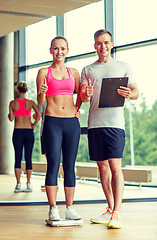 Image showing smiling man and woman with scales in gym