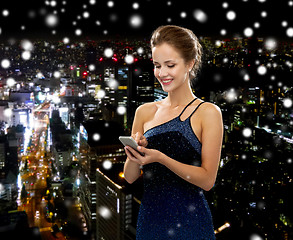 Image showing smiling woman in evening dress with smartphone