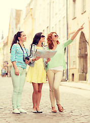 Image showing smiling teenage girls with map and camera