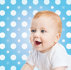 Image showing smiling baby boy face over blue polka dots