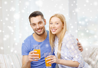 Image showing smiling happy couple at home drinking juice