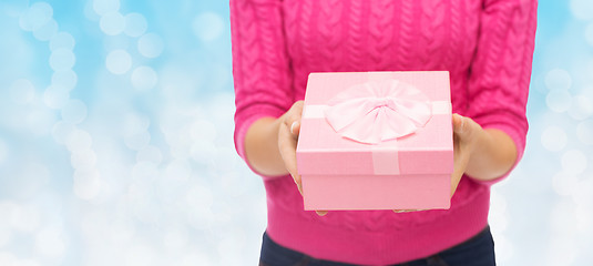 Image showing close up of woman in pink sweater holding gift box