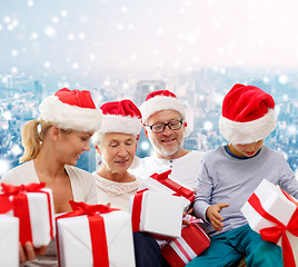 Image showing happy family in santa helper hats with gift boxes