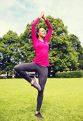 Image showing smiling african american woman exercising outdoors