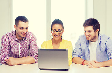 Image showing three smiling colleagues with laptop in office