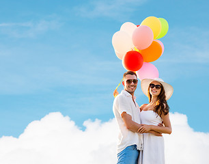 Image showing smiling couple with air balloons outdoors