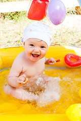 Image showing Little 9 monthes old girl swims in pool